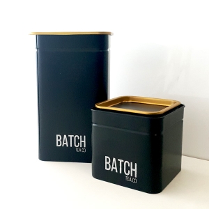 Photograph of a large and a small engraved tea tin